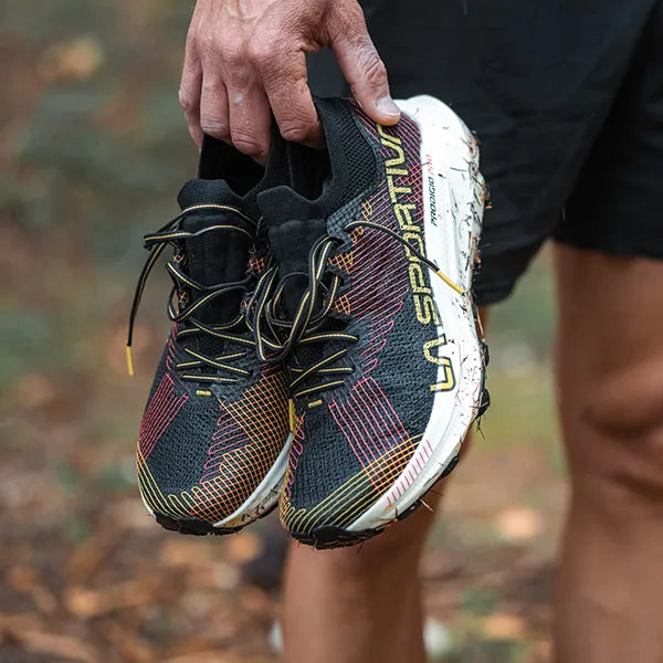 Primo piano scarpe da trail in mano ad un ragazzo