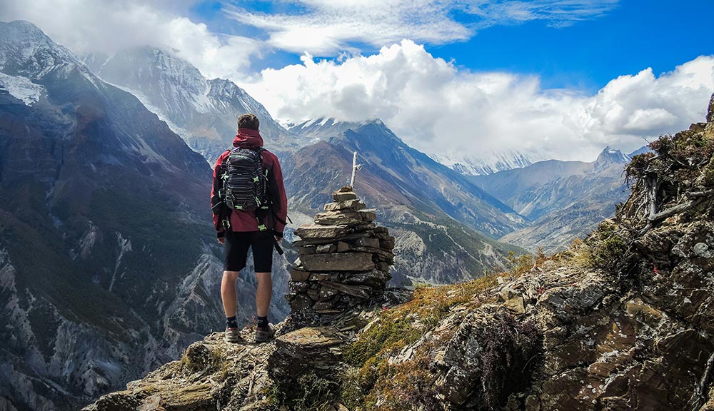 ragazzo di spalle in montagna che guarda il panorama
